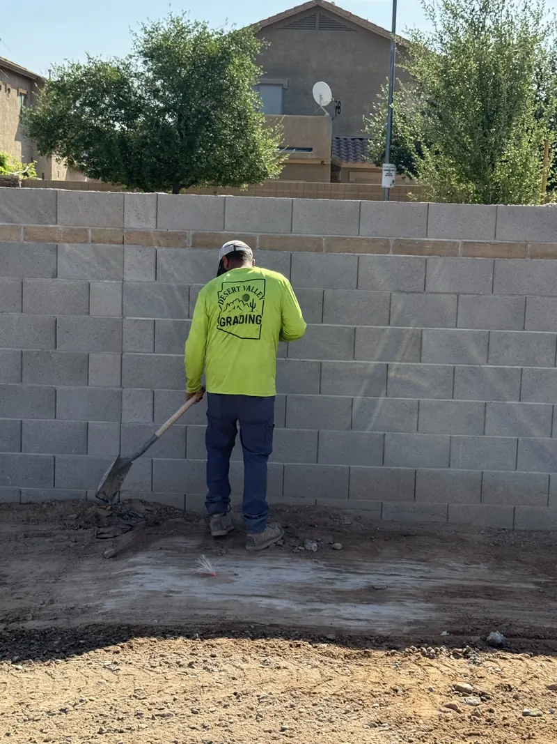 Desert Valley Grading crew member performing fine grade work